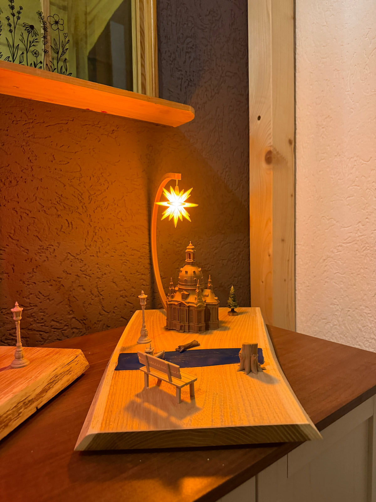 Dresdner Frauenkirche mit Epoxidharz-Elbe, gelb leuchtendem Herrnhuter Stern® und dekorativen Miniaturelementen auf Holz