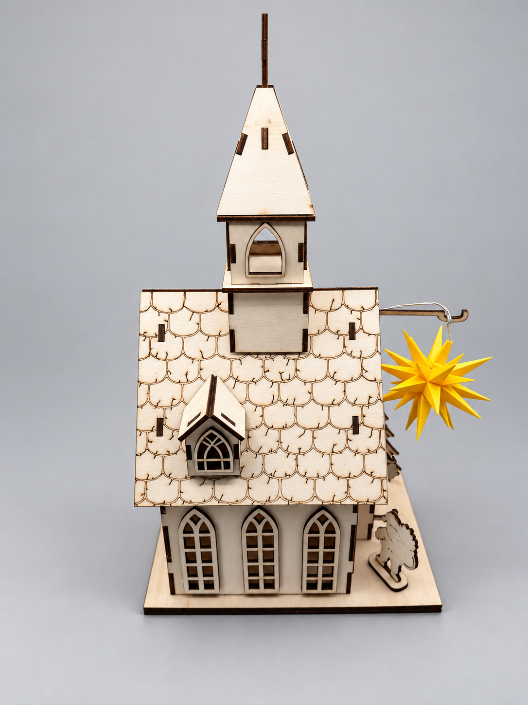 Holzkirche mit Herrnhuter Stern – Seitenansicht mit Kirchturm und graviertem Schindeldach