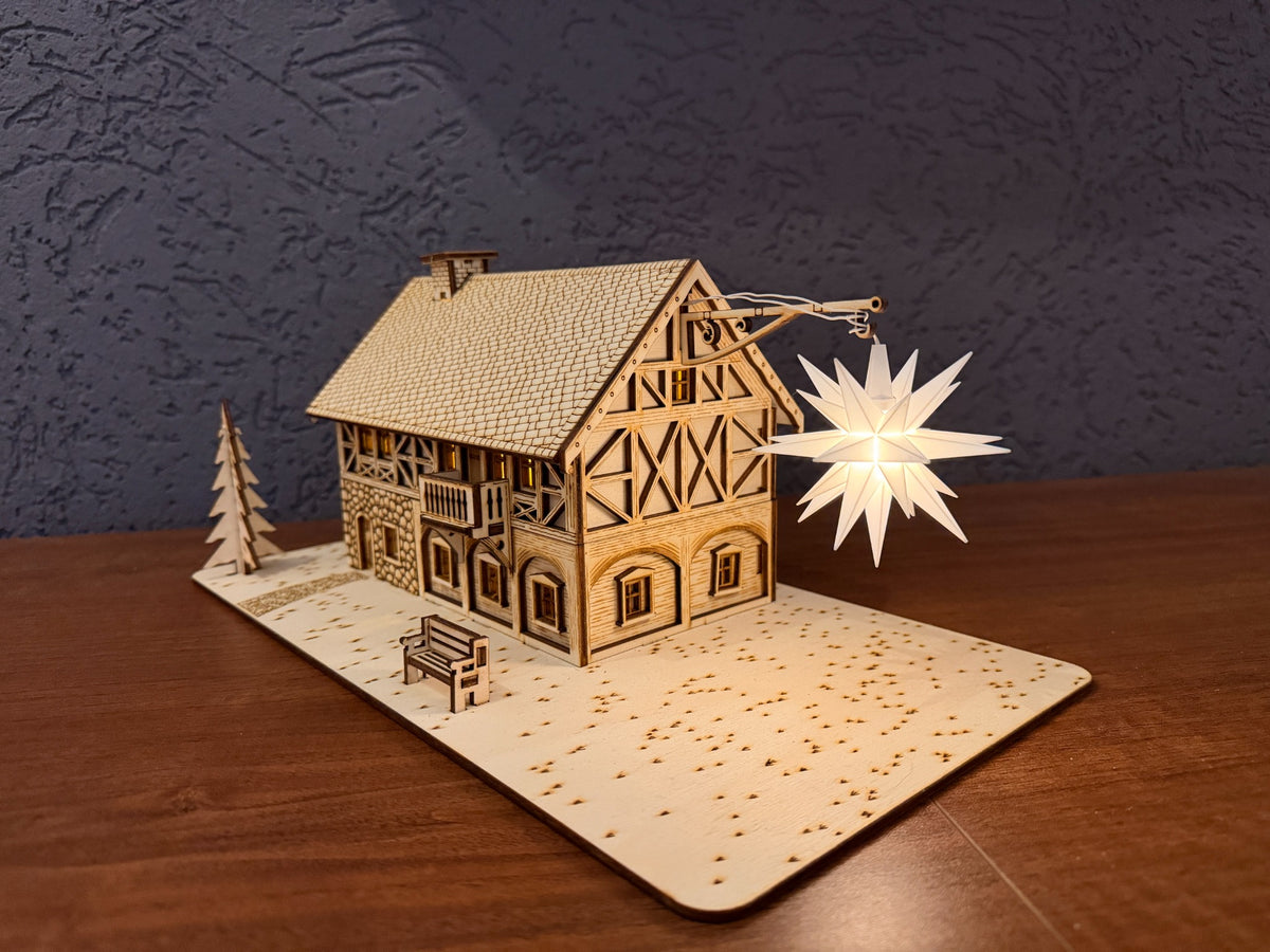 Umgebindehaus Holz in Schrägansicht mit fein ausgearbeitetem Fachwerkgiebel und leuchtendem Herrnhuter Stern.